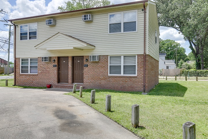 the front of a house with a sidewalk in front of it